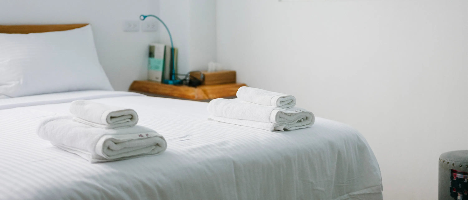 a clean bed with towels on top representing a cleaning service detail