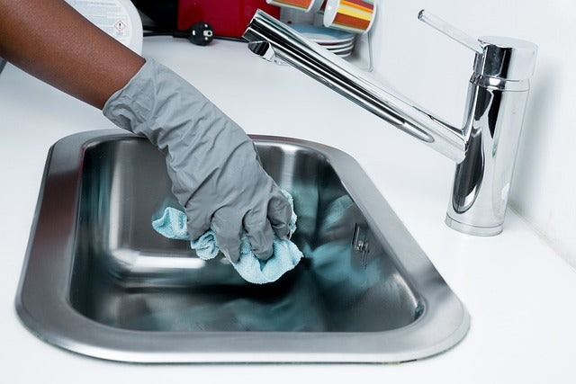 hand of a house cleaners cleaning a sink