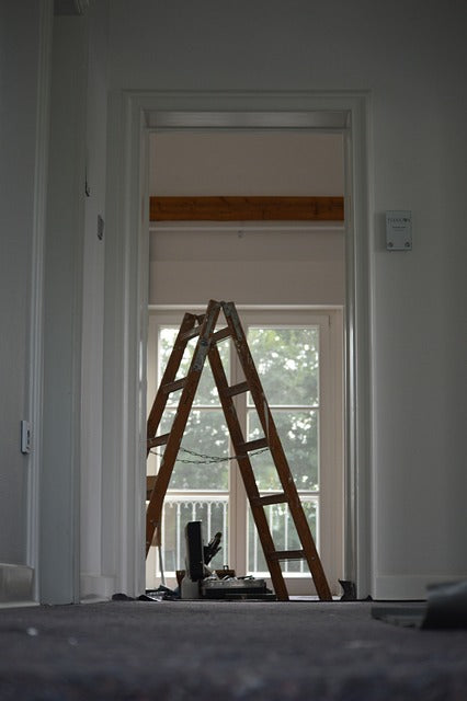 an empty bedroom under renovation with a ladder in the middle